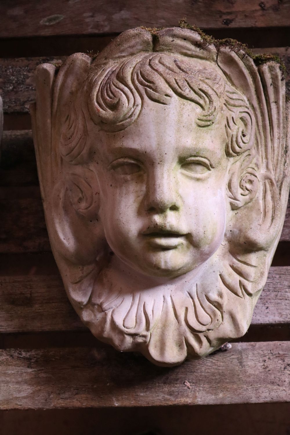 Three reconstituted stone cherub garden wall appliques, tallest 32cm